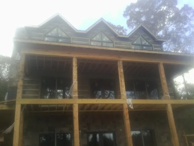 Dormers and porch framing on a large log home under construction — Roof Coating work by our crew in Clearwater